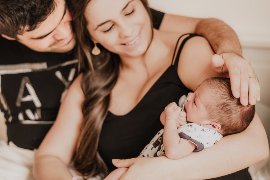 Junge Eltern mit ihrem Baby im Arm