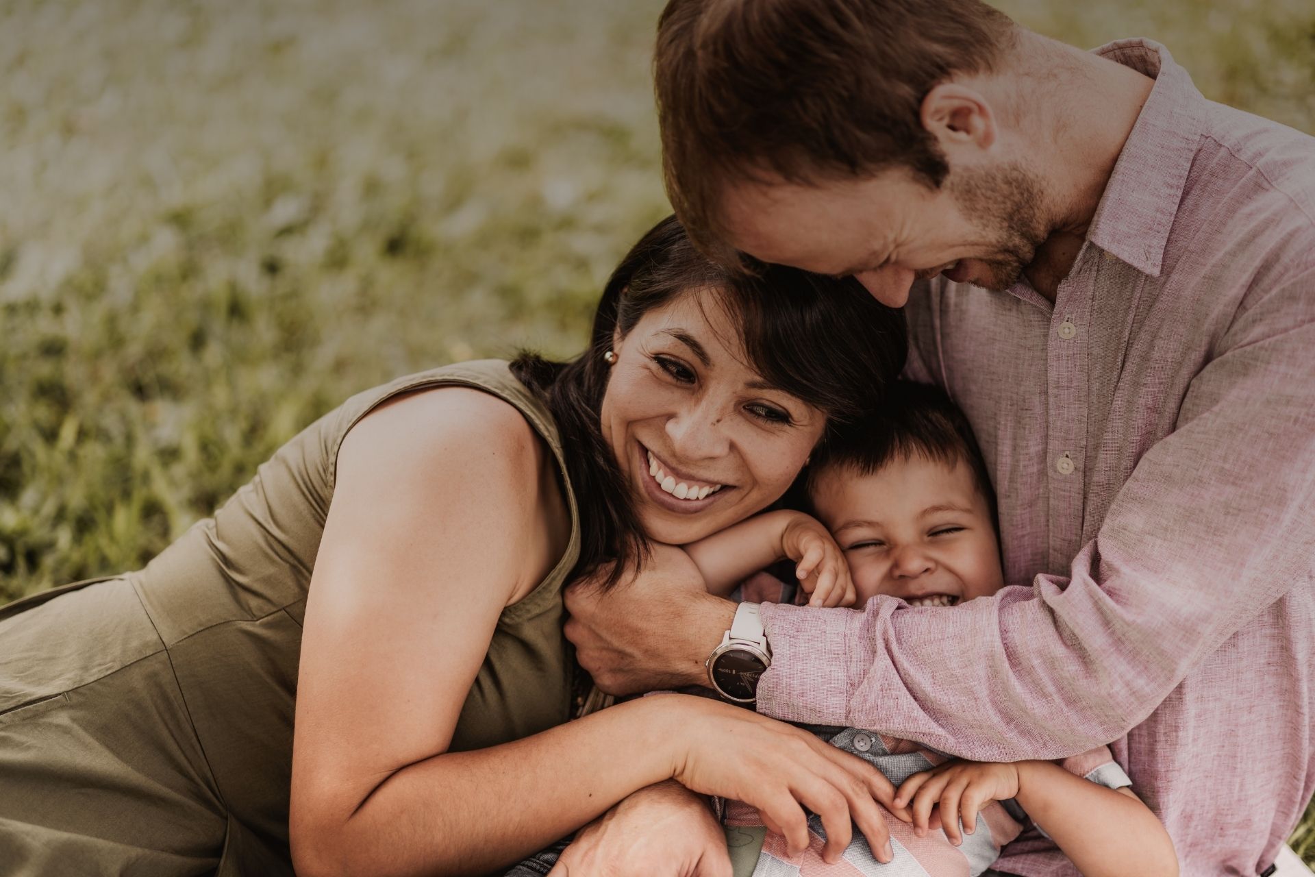 Familie mit Mama, Papa und Sohn in inniger Umarmung