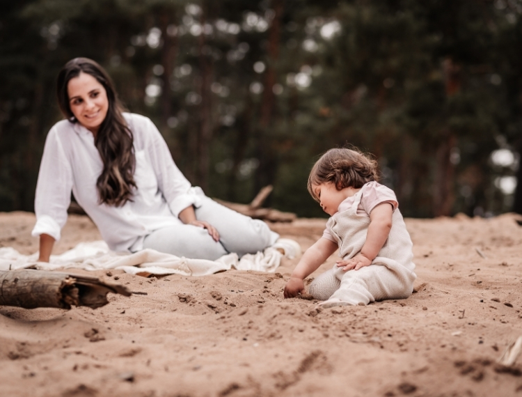 Mama mit kleiner Tochter im sitzen im Sand beim Familienfotoshooting auf der Sandduene in Nürnberg.