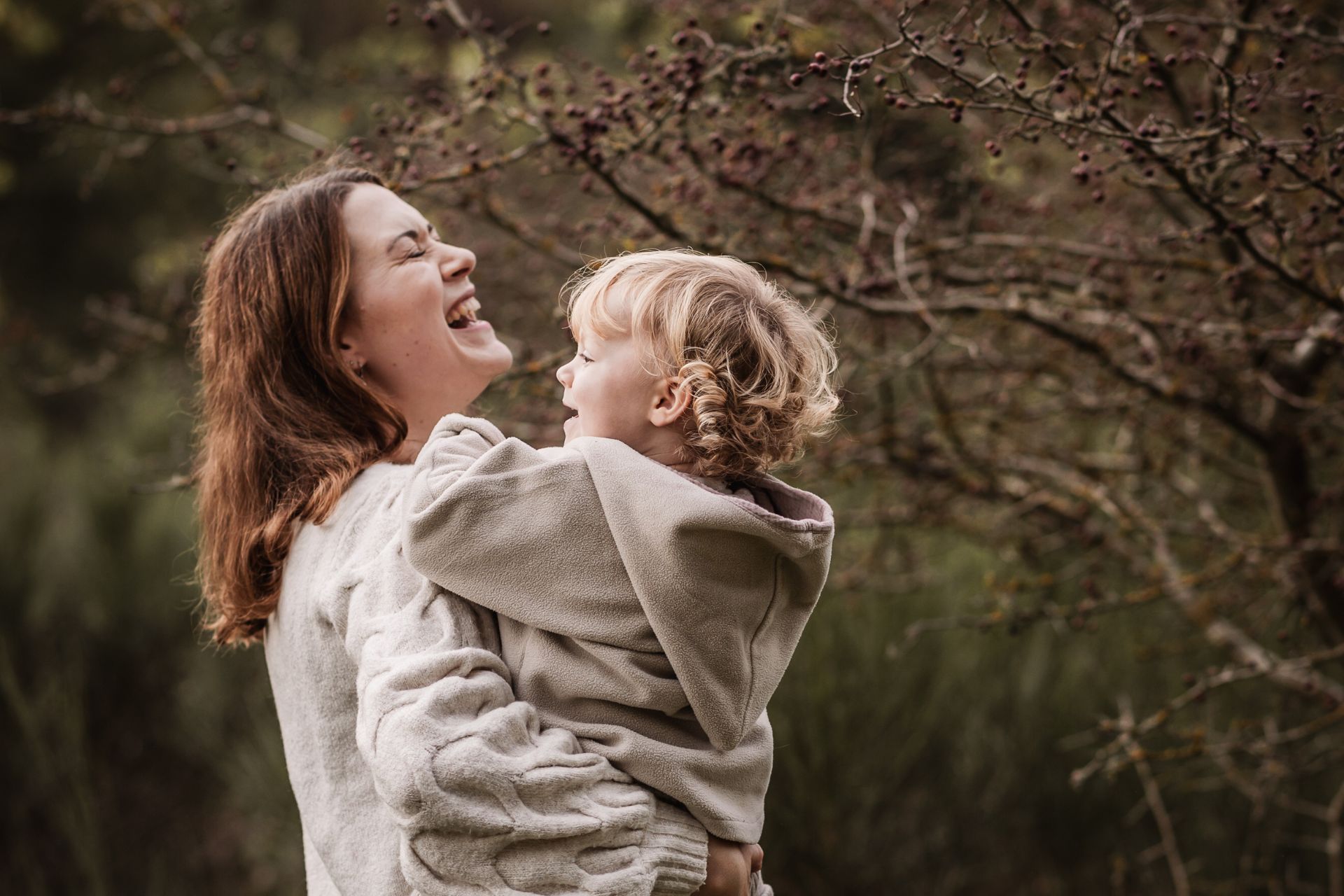 Mama mit Tochter auf dem Arm lacht herzlich beim Familienfotoshooting in Nürnberg.