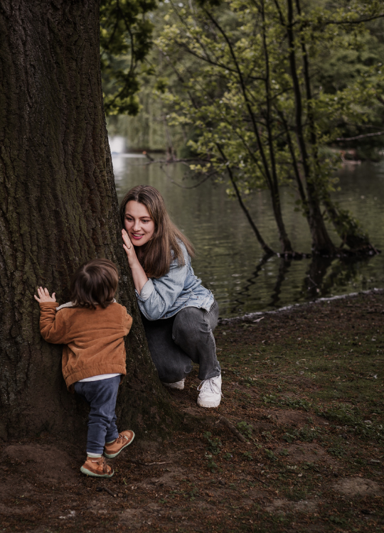 Mama mit Sohn beim verstecken im Park