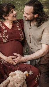 Familie mit werdender Mama auf einer Picknickdecke im Park