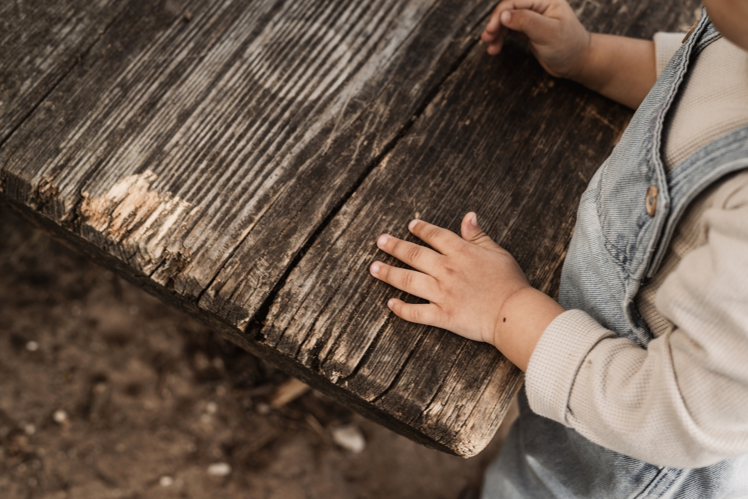 Kinderhand auf rustikaler bank im freien.