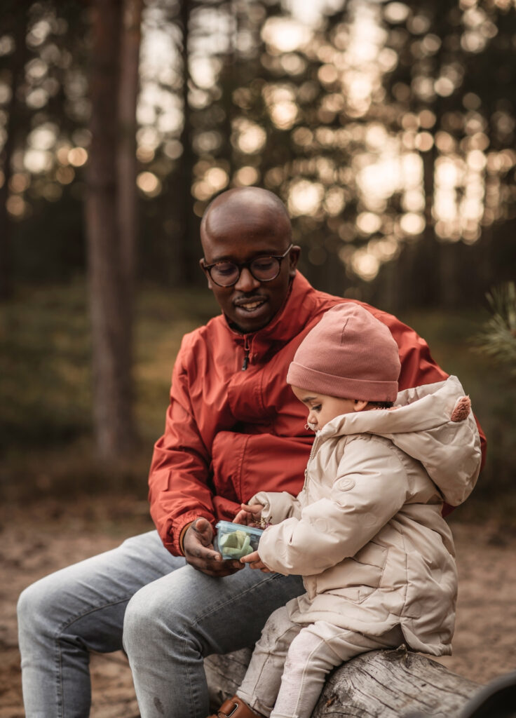 Papa mit kleinem Kind machen eine Pause und essen Snacks am fränkischen Dünenweg