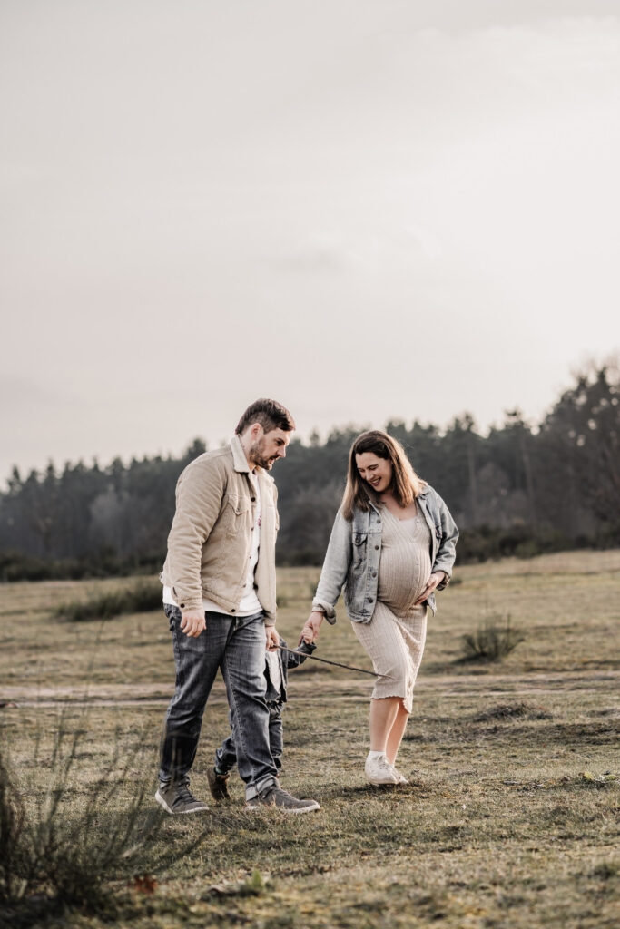 Familie mit KLeinkind und werdender Mama bei einem Spaziergang in der Natur beim Familien- und Babybauch-Fotoshooting in Nürnberg