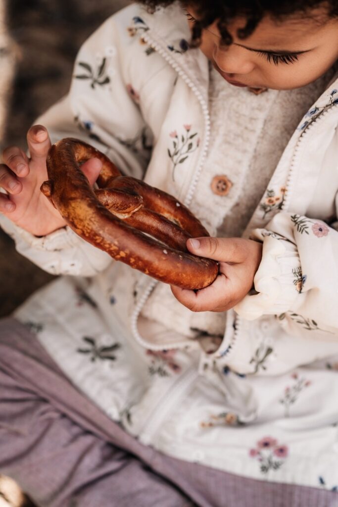 Hände eines Kleinkindes mit einer Breze