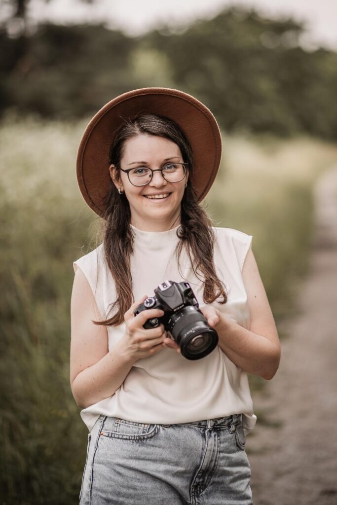 Frau mit Kamera in Hand in der Natur in Nürnberg.